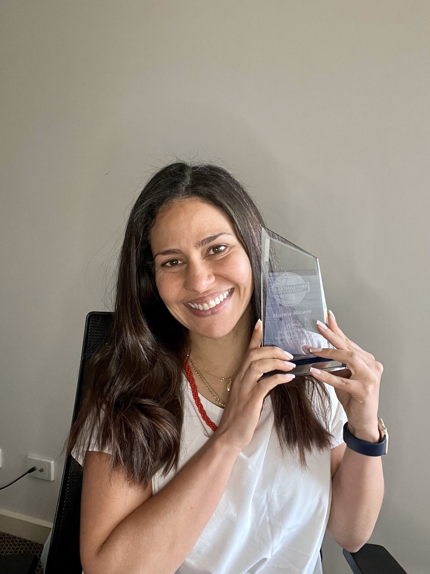 Mariana Marcano Franco holding her award as the winner of the Toastmasters International speech contest 